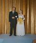Photograph: [Man and woman in formal attire standing on a stage]