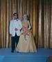 Photograph: [Man and woman in formal attire posing in front of a curtain backdrop]