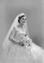 Photograph: [Woman wearing a wedding dress and veil, holding a bouquet]