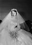 Photograph: [Norma Sexton wearing a large wedding dress and holding her bouquet]