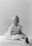 Photograph: [Little girl sitting on a floor, wearing a dress]