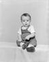 Photograph: [Toddler boy in overalls, boots and a short-sleeve shirt]
