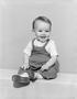 Photograph: [Photograph of toddler boy in overalls, boots and a short-sleeve shir…