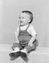 Photograph: [A toddler boy in overalls smiling for picture]