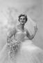 Photograph: [Portrait of Jane Williams in a wedding dress, holding a bouquet, one…