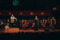 Photograph: [Symphony Orchestra, conductor, and two singers on stage at the UNT C…