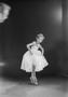 Photograph: [Suzie De Shazo posing in ballet attire, on pointe, holding her skirt…