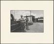 Photograph: [Two men standing next to a truck]