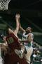 Photograph: [UNT men's basketball player blocks member of opposing team under net]