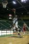 Photograph: [UNT women's basketball player attempts to dunk ball during game]