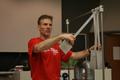 Photograph: [Man performs pendulum demonstration at the Physics Olympics]
