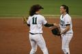 Photograph: [Rebecca Waters converses with teammate on field during softball game]