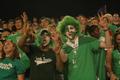 Photograph: [Men in face paint pose with eagle claws at UNT football game]