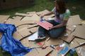 Photograph: [Woman paints American flag during Shack-a-thon fundraising event]