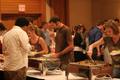 Primary view of [Photograph of people plating food at murder mystery dinner]
