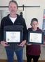 Primary view of [Scott Hamilton and son hold induction certificates]