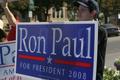 Photograph: [Photograph of a man holding a Ron Paul sign on the Square]