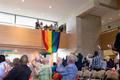 Primary view of [Unfurling pride flag at LGBTQ reception, from below]