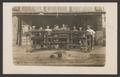 Photograph: [Justin Boot Co. workers with boots on a drying rack]