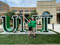 Photograph: [UNT Eagle Ambassadors posing in front of the UNT letters]
