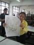 Photograph: [Woman holds drawing of Suvannamaccha in Thailand classroom]