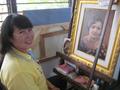 Photograph: [Woman with painted portrait in Thailand classroom]