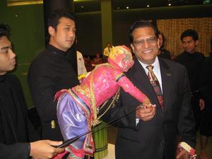 Primary view of object titled '[Vish Prasad poses with Thai puppet, 1]'.
