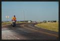 Photograph: [A motorcyclist and a biker rounding a turn: Lone Star Ride 2002 even…