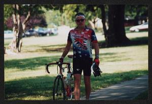 Primary view of object titled '[Cyclist Chuck Taylor walking with his bike: Lone Star Ride 2002 event photo]'.