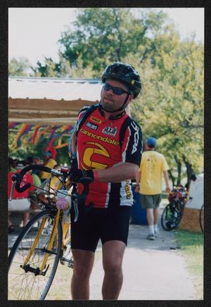 Primary view of object titled '[Leonard Fiorenza carrying his bike: Lone Star Ride 2002 event photo]'.
