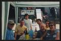 Thumbnail image of item number 1 in: '[7 people sitting under a stripped tent by a wooden deck: Lone Star Ride 2003 event photo]'.