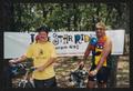 Primary view of [Two cyclists in font of a banner: Lone Star Ride 2003 event photo]