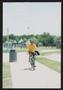 Photograph: [Cyclist in yellow waving as he rides in: Lone Star Ride 2003 event p…