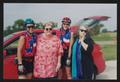 Primary view of [Four people posing by a red car with its hatch open: Lone Star Ride 2003 event photo]
