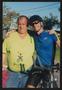 Primary view of [Cyclist hugging a crew member from his bike: Lone Star Ride 2003 event photo]