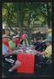 Photograph: [Crew and cyclists eating at a table taped with a sign]