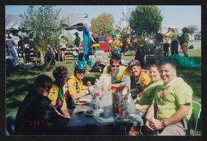 Primary view of object titled '[Group of 7 sitting around a table eating lunch: Lone Star Ride 2003 event photo]'.