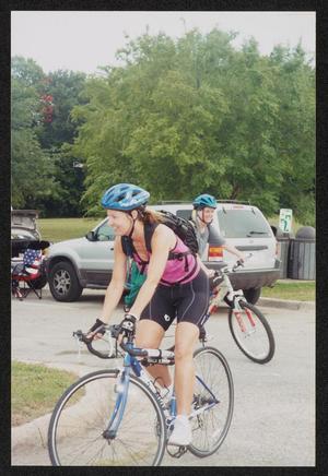 Primary view of object titled '[Woman in pink cycling outfit rounding a curve: Lone Star Ride 2004 event photo]'.