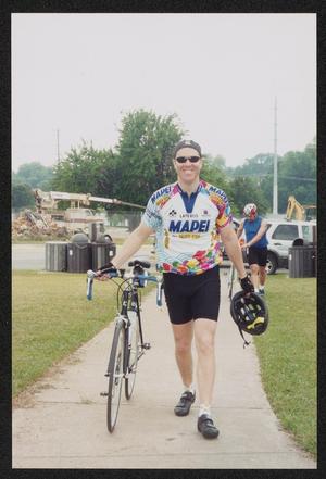 Primary view of object titled '[Cyclists walking with their bikes: Lone Star Ride 2004 event photo]'.
