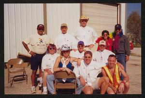 Primary view of object titled '[Pit stop group smiling into direct sun without Janie Bush: Lone Star Ride 2001 event photo]'.
