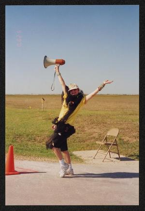 Primary view of object titled '[Crew member striking a pose with a megaphone: Lone Star Ride 2001 event photo]'.