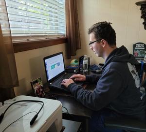 Primary view of [Bryan Salazar working on school assignments at his home desk]