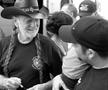 Photograph: [Willie Nelson signs autographs before BioWillie press conference]