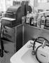 Photograph: [Photograph of a sink and cash register at a barber's shop]