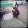 Photograph: [People seated on a sidewalk in Tarabucu]