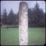 Photograph: [A tall carved stone in a field]
