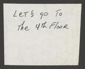 A note written in black ink on a scrap of paper. The note reads, Let’s go to the 4th floor.