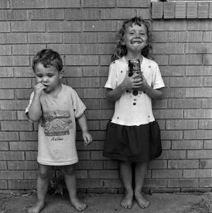 Primary view of object titled '[Two children standing in front of a brick wall #4]'.