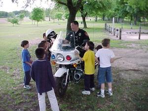 Primary view of object titled '[Children gather around police motorcycle]'.