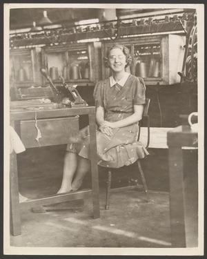 Primary view of object titled '[Factory worker seated at her station]'.